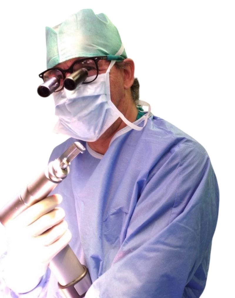 Il Dr. Mario Commodo in sala operatoria, con occhiali ingrandenti e strumentario chirurgico